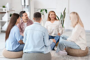 Smiling mature woman talking at group therapy session
