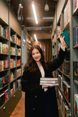 Pretty teen gen Z Korean student girl chooses book in a bookstore. Education training concept. Part of a series