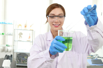Portrait of happy beautiful Asian scientist woman in lab coats with safety glasses do science...
