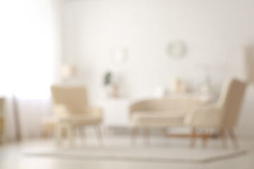 Blurred interior of living room with sofa and armchairs