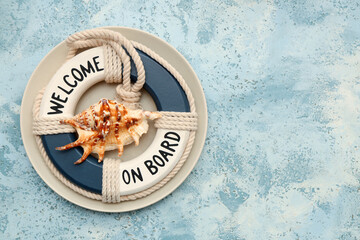 Beautiful plate with seashell and lifebuoy on blue grunge background