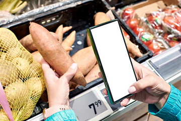 Sweet potato vegetable in hand and smartphone