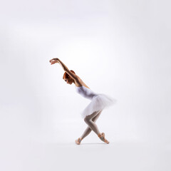Ballet dancer isolated on white. Beautiful ballerina performing in studio.