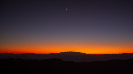 Sunset or evening time over the mountain with small half moon.