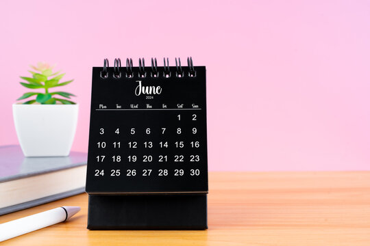 June Mini desk calendar for 2024 year on worktable with pink background.