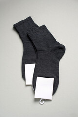 Mens new socks on a gray background, close-up. Cotton socks with blank label