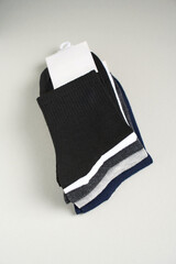 Mens new socks on a gray background, close-up. Cotton socks with blank label