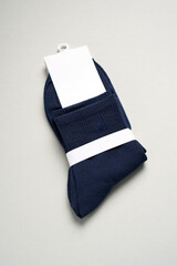 Mens new socks on a gray background, close-up. Cotton socks with blank label
