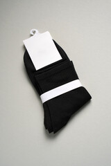 Mens new socks on a gray background, close-up. Cotton socks with blank label