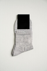 Mens new socks on a gray background, close-up. Cotton socks with blank label