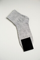Mens new socks on a gray background, close-up. Cotton socks with blank label