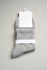 Mens new socks on a gray background, close-up. Cotton socks with blank label