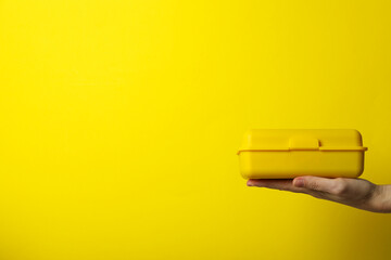 Yellow lunch box on a yellow background