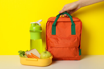 A yellow lunch box with a school bag