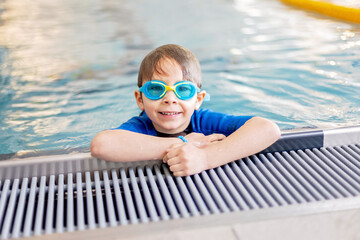 Cute preschool child, boy, swimming in swimming pool, wearing wetsuit - 796284944