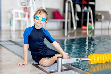 Cute preschool child, boy, swimming in swimming pool, wearing wetsuit - 796284960