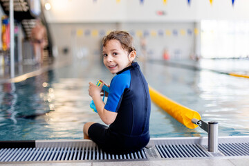 Cute preschool child, boy, swimming in swimming pool, wearing wetsuit - 796284966