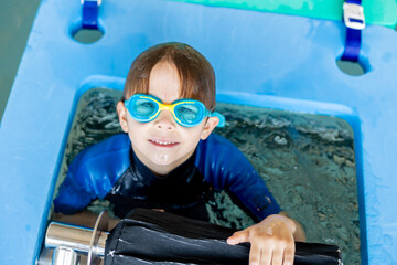 Cute preschool child, boy, swimming in swimming pool, wearing wetsuit - 796284987
