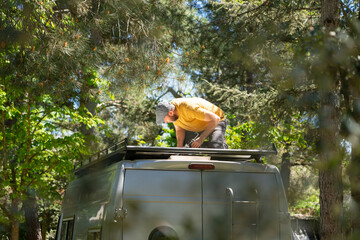Caucasian man fixing the roof of a camper van