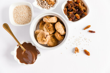 Ingredient for healthy dessert. Nuts, chocolate,seeds, figs, raisins. Sugar free. Vegetarian organic food. White background, top view