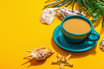 A cup of coffee in a marine style. Starfish, shells, palm leaves. Hard light, dark shadow