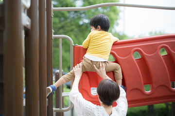 Obraz premium お母さんと一緒に公園で遊ぶ子供 子育てや育児のイメージ 顔なしのイメージ