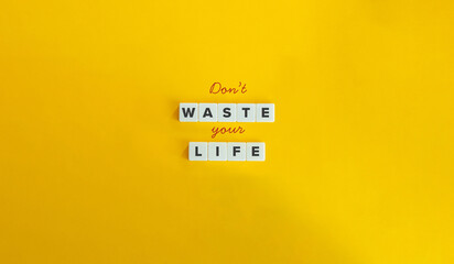 Don’t Waste Your Life Phrase. Concept of Living Purposefully and Meaningfully, Striving for Personal Growth and Fulfilment. Cursive Font and Text on Block Letter Tiles on Yellow Background.