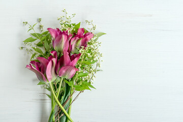 Bouquet of pink and green tulips and branches with white flowers on a white background