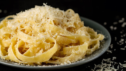 pasta with parmesan cheese, dark background, close-up.