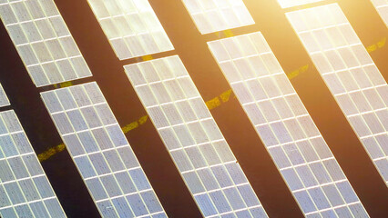Bathed in sunlight, the photovoltaic power station harnesses solar rays, transforming them into a sustainable source of power. Renewable resources and clean energy concept. Aerial view drone.
