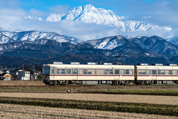 剱岳を眺めながら走る富山地方鉄道の電車