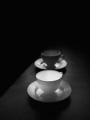 two empty white cups stand on a saucer