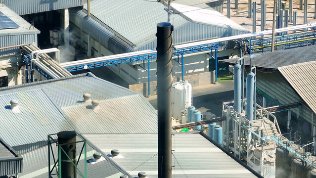 The industrial plant exhales smoky tendrils, a somber dance of pollution, staining the heavens with its remorseless embrace of nature's demise. Environmental impact and carbon dioxide concept. Drone.
