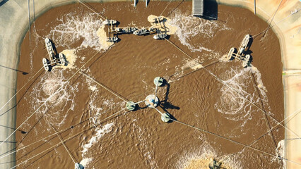 An industrial wastewater treatment pond purifies contaminated water, removing pollutants and...