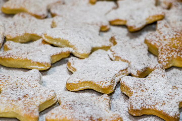 Homemade baking. Cookies in the shape of stars and hearts are sprinkled with powdered sugar. Christmas cookies. View from above. Selective focus.