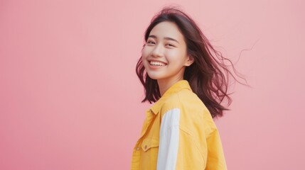 Fototapeta premium A woman in a yellow jacket is smiling and looking at the camera