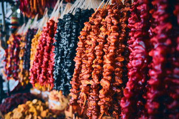Bunches of bright traditional churchkhela sweets made of different nuts. Colorful churchkhelas at...