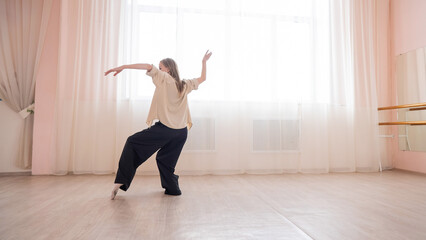 Fototapeta na wymiar Caucasian woman dancing contemporary in ballet class. Rehearsal.