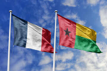 3d illustration. France and Guinea-Bissau Flag waving in sky. High detailed waving flag. 3D render. Waving in sky. Flags fluttered in the cloudy sky.