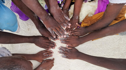 Afrikanische Kinderhände im Sand auf Sansibar