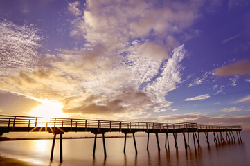 Sunset, Scarness jetty, Hervey Bay, Queensland.  Long exposure, sunburst sunstar, smooth water blue...