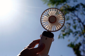 Hand holding a portable rechargeable electric fan