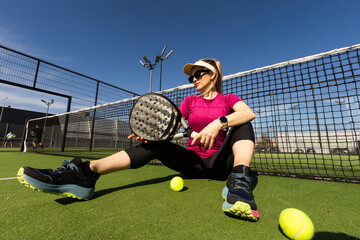 Happy female paddle tennis player during practice on outdoor court looking at camera. Copy space. - 796338565