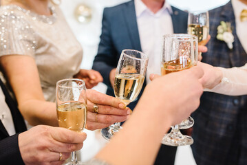 Cheers. People celebrate and raise glasses of wine for toast. Group of man and woman cheering with...