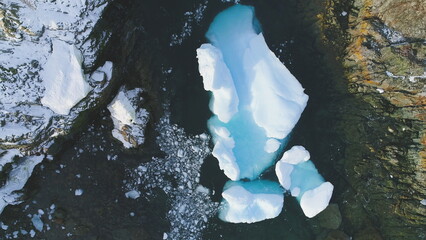 Iceberg Stuck In Peninsula Ocean Shore Aerial View. Big Turquoise Ice Piece Melting at Antarctica...