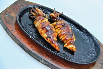 Grilled squids or 'Cumi Bakar' is a sweet and tangy seafood dish that is often sold as street food in Indonesia. It is marinated in sweet soy sauce and a mixture of spices before being grilled. 