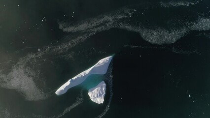 Antarctica iceberg aerial drone view flight. Fast top down. Overview the lone snow white ice...