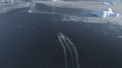 Zodiac Boat Sail Antarctica Aerial Tracking. Drone Flight Overview of South Pole Ocean Landscape. Rubber Boat Float in Winter Open Water Brash Ice. - obrazy, fototapety, plakaty