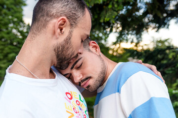 An LGBT couple embraces, sharing a tender moment as the day ends.