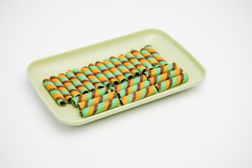 Wafer sticks containing sweet chocolate in a container on a white background